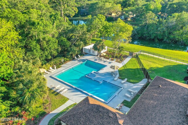 view of pool with a water view, a yard, and a patio area