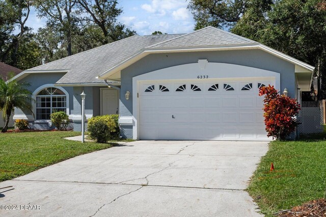 ranch-style home featuring a garage and a front yard