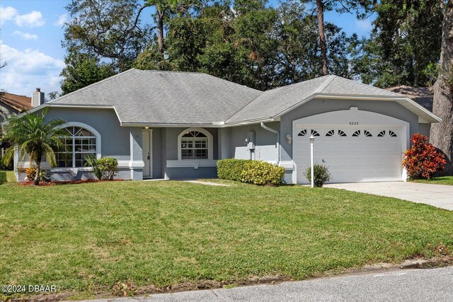 ranch-style home with a garage and a front yard