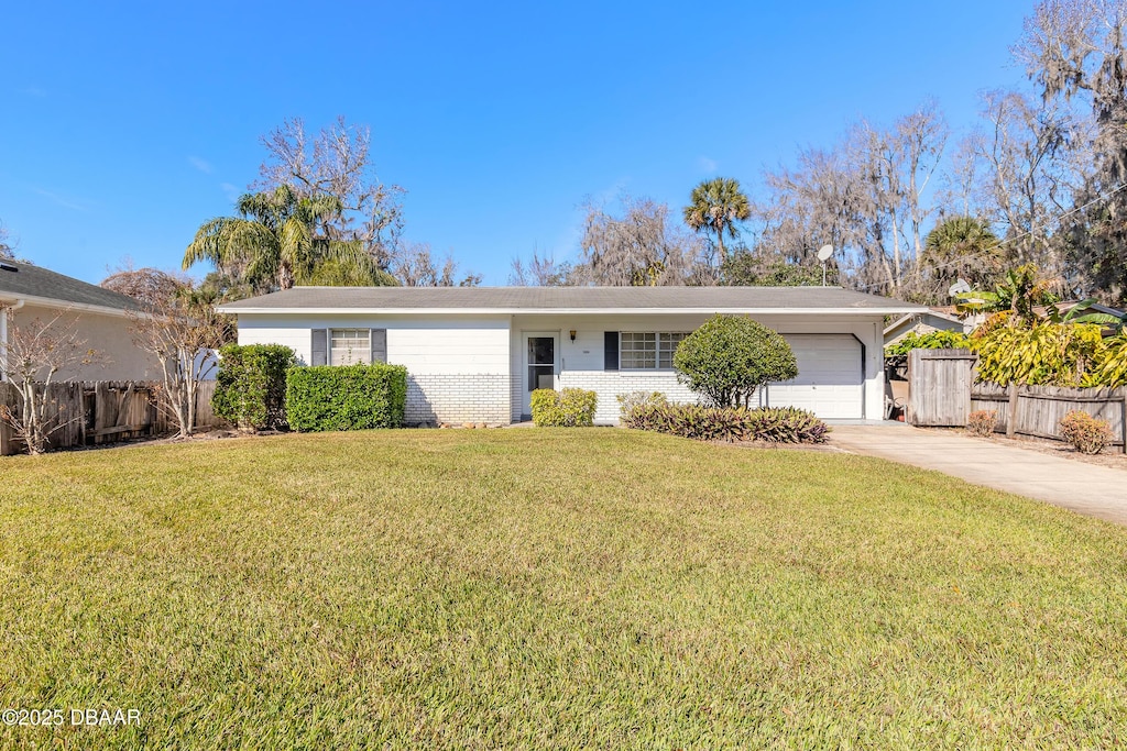 single story home with a garage and a front lawn