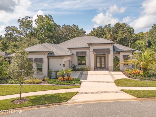 prairie-style home with a front yard and french doors