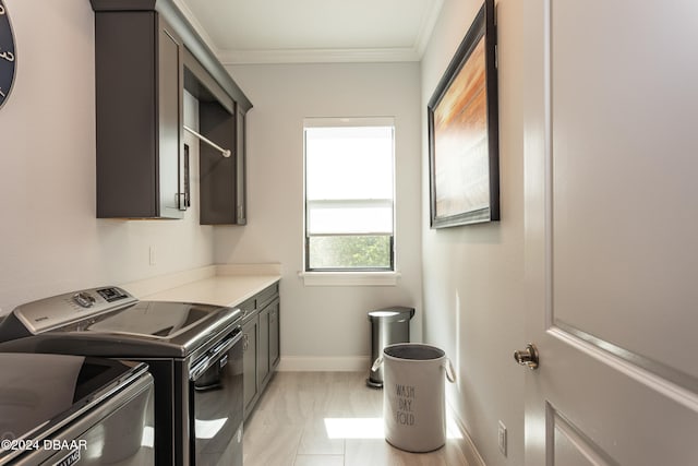 washroom featuring cabinets, ornamental molding, and washing machine and dryer