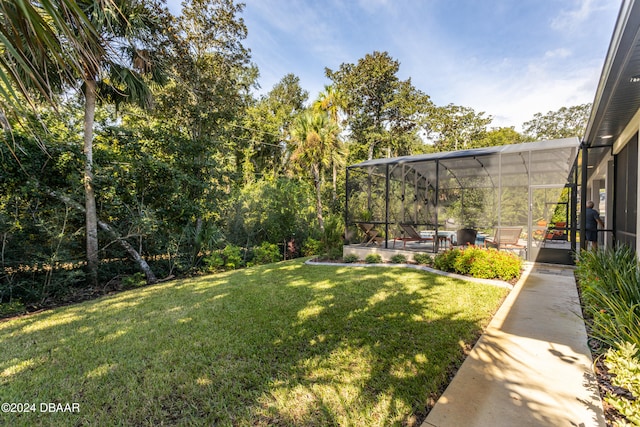 view of yard featuring glass enclosure and a patio area