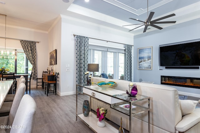 living room featuring hardwood / wood-style floors, a wealth of natural light, crown molding, and ceiling fan