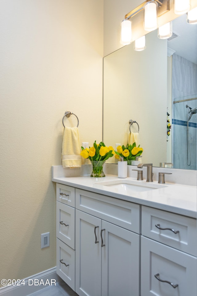 bathroom featuring a tile shower and vanity