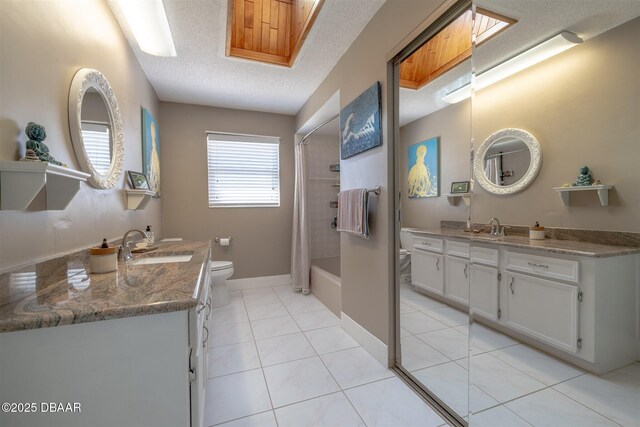 full bathroom with a sink, toilet, tile patterned floors, and a textured ceiling