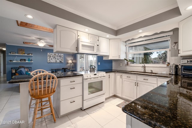 kitchen with crown molding, a peninsula, light tile patterned flooring, white appliances, and a sink