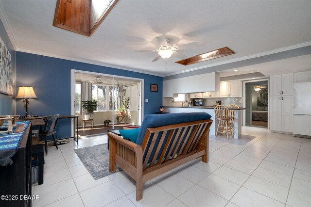 bedroom featuring a skylight, light tile patterned floors, freestanding refrigerator, and ornamental molding