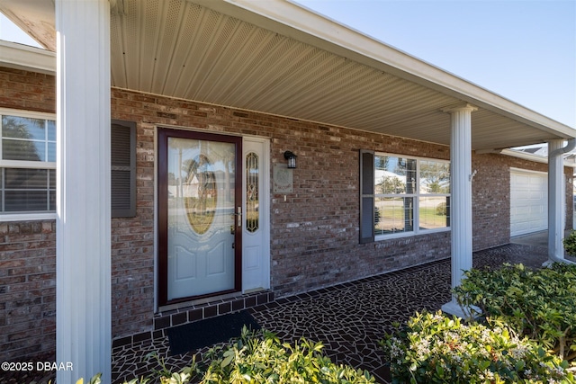 property entrance with brick siding and covered porch