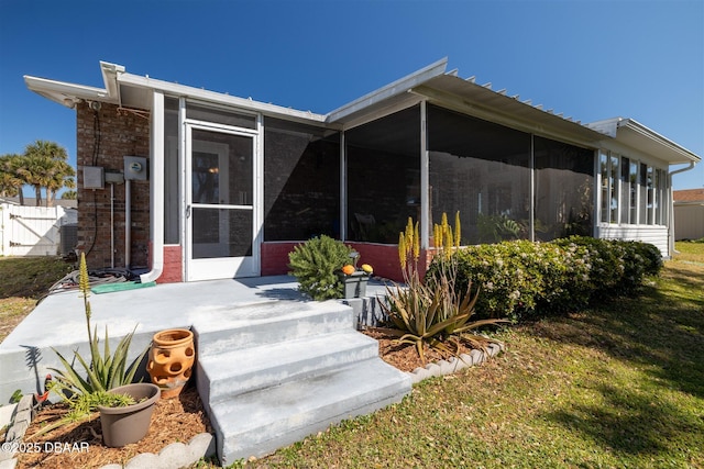 rear view of house with fence and a sunroom