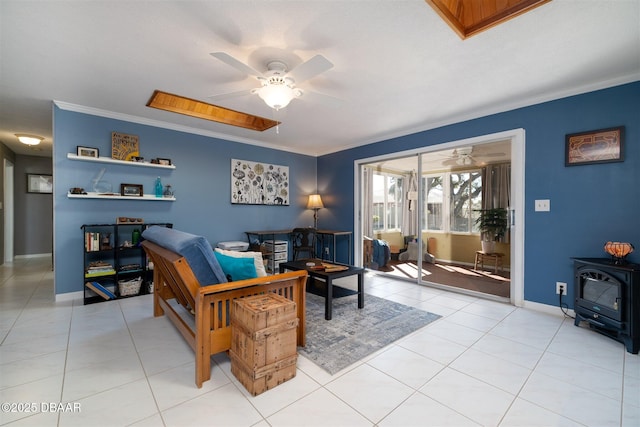 living area featuring crown molding, light tile patterned floors, baseboards, ceiling fan, and a wood stove