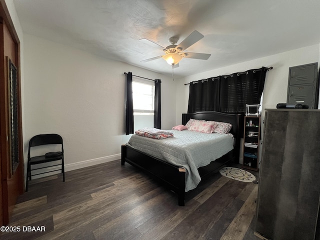 bedroom with a ceiling fan, baseboards, and dark wood-style flooring