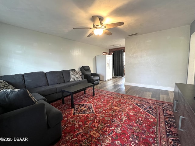 living room featuring ceiling fan, dark wood finished floors, and baseboards