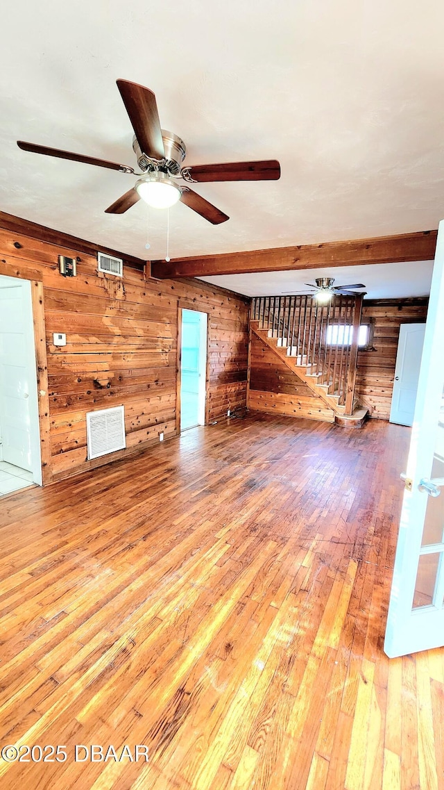 524 W St, Daytona Beach, FL 32114 - unfurnished living room featuring wooden walls, hardwood / wood-style flooring, a ceiling fan, and stairs