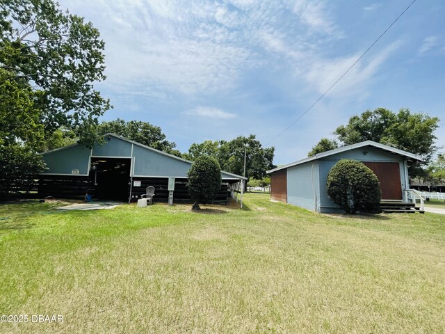 3565 E Lake Dr, Land Olakes, FL 34639 - view of grassy yard featuring a pole building, an outbuilding, and a detached garage