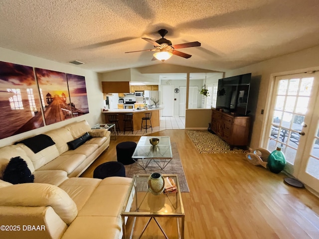 3565 E Lake Dr, Land Olakes, FL 34639 - living room with light wood finished floors, ceiling fan, a textured ceiling, and vaulted ceiling