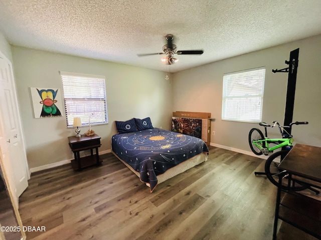 3565 E Lake Dr, Land Olakes, FL 34639 - bedroom with wood finished floors, a textured ceiling, multiple windows, baseboards, and ceiling fan