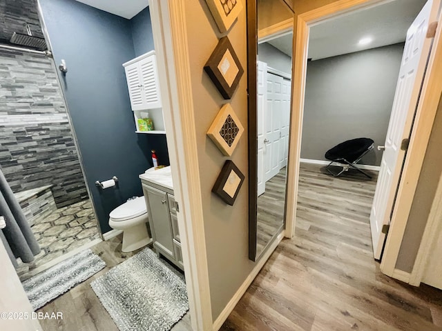3565 E Lake Dr, Land Olakes, FL 34639 - full bath with a tile shower, toilet, wood finished floors, vanity, and baseboards