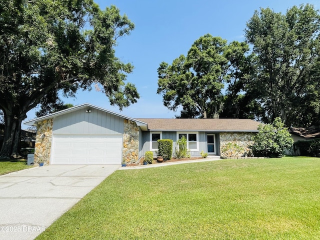 3565 E Lake Dr, Land Olakes, FL 34639 - single story home featuring stone siding, an attached garage, a front yard, and driveway