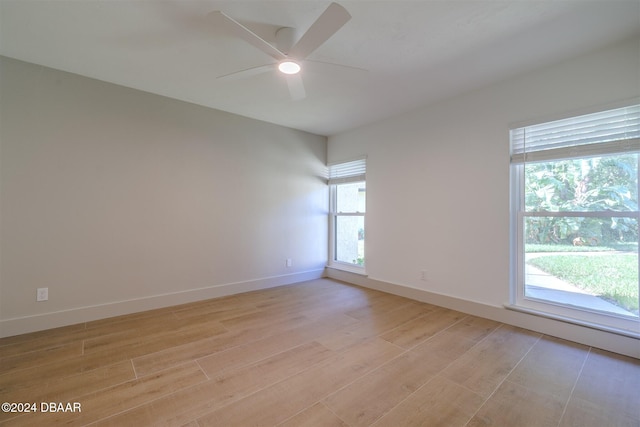 unfurnished room with ceiling fan, a wealth of natural light, and light hardwood / wood-style floors