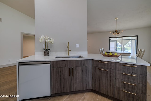 kitchen featuring dishwasher, kitchen peninsula, light hardwood / wood-style floors, and sink