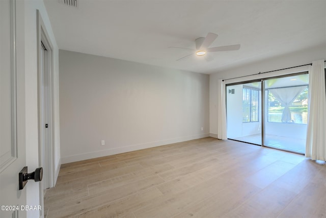 empty room with ceiling fan and light hardwood / wood-style flooring