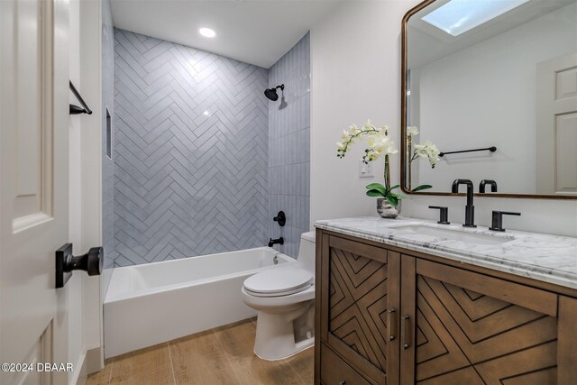 full bathroom with wood-type flooring, toilet, vanity, and tiled shower / bath