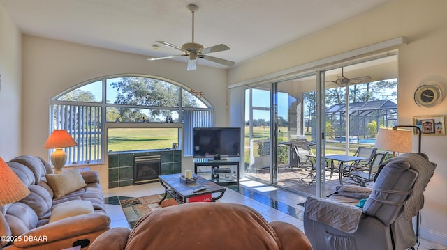 tiled living room with ceiling fan and a fireplace