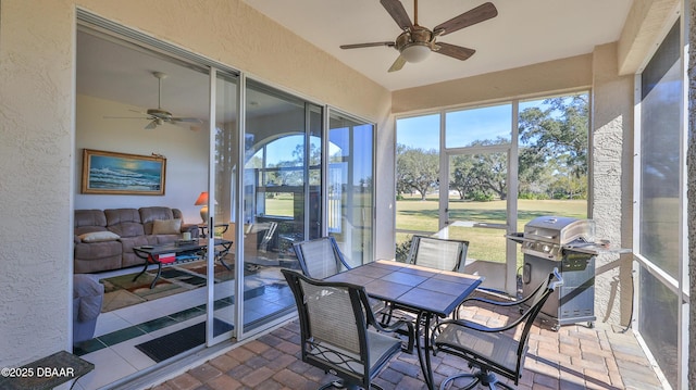 sunroom featuring ceiling fan and plenty of natural light