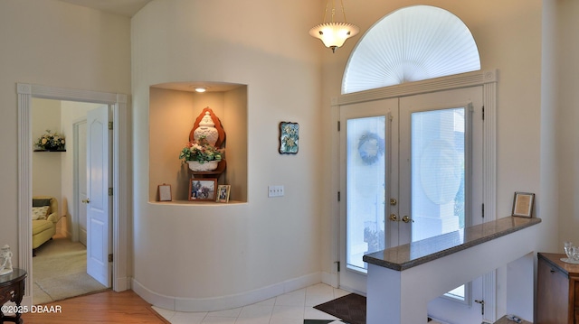 entryway featuring a towering ceiling and french doors