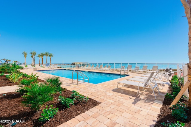 view of pool featuring a patio and a water view