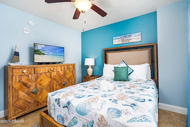 tiled bedroom with ceiling fan and a textured ceiling