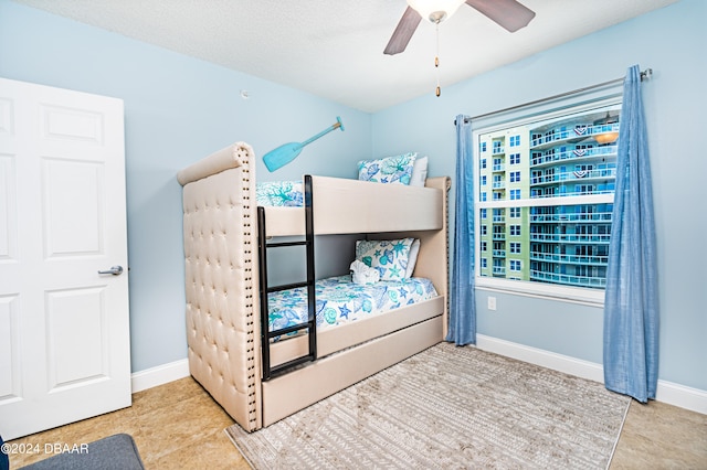 tiled bedroom featuring ceiling fan