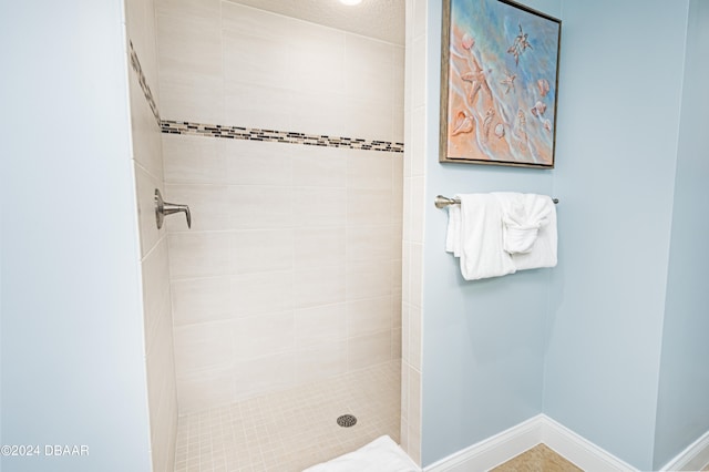 bathroom with a tile shower and a textured ceiling