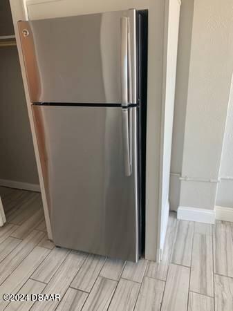 800 N Atlantic Ave Unit 508, Daytona Beach, FL 32118 - detailed view of freestanding refrigerator, wood finish floors, and baseboards