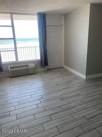 800 N Atlantic Ave Unit 508, Daytona Beach, FL 32118 - spare room with baseboards, a textured ceiling, healthy amount of natural light, and wood tiled floors