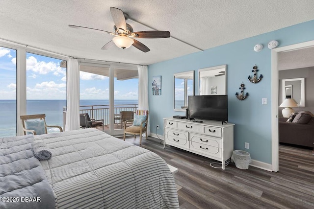 3555 S Atlantic Ave Unit 602, Daytona Beach, FL 32118 - bedroom featuring a textured ceiling, access to exterior, dark wood-style flooring, and ceiling fan