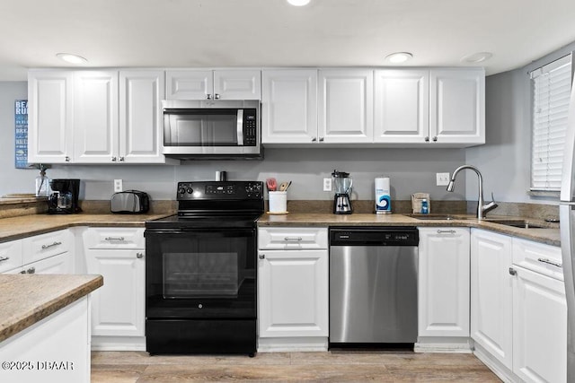 3555 S Atlantic Ave Unit 602, Daytona Beach, FL 32118 - kitchen featuring appliances with stainless steel finishes, white cabinets, light wood-style floors, and recessed lighting