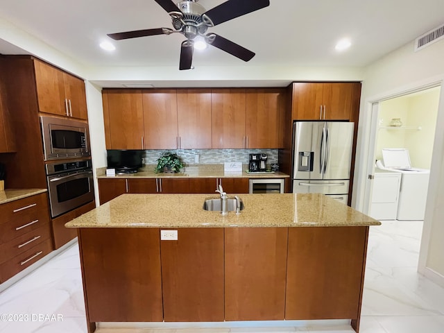 1925 S Atlantic Ave Unit 411, Daytona Beach Shores, FL 32118 - kitchen with stainless steel appliances, separate washer and dryer, light marble finish floors, a sink, and decorative backsplash