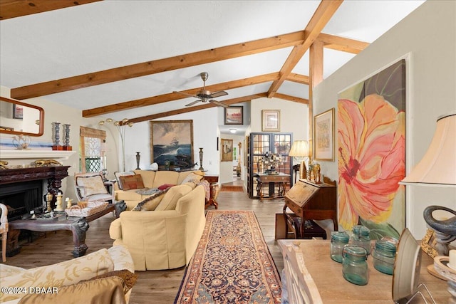 living room featuring hardwood / wood-style floors, vaulted ceiling with beams, and ceiling fan