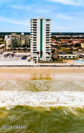 view of building exterior with a view of the beach and a water view