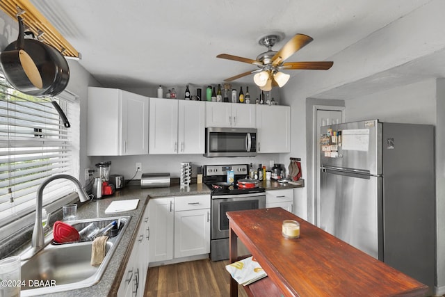 kitchen featuring dark hardwood / wood-style flooring, white cabinets, sink, ceiling fan, and appliances with stainless steel finishes