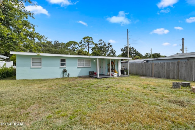 back of house featuring a lawn and a patio