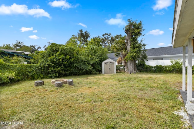 view of yard featuring a fire pit and a storage shed