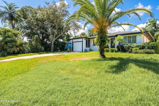 view of front of property featuring a garage and a front lawn