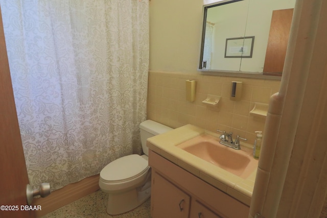 17 Putnam Ave, Ormond Beach, FL 32174 - bathroom featuring vanity, tile walls, curtained shower, speckled floor, and wainscoting