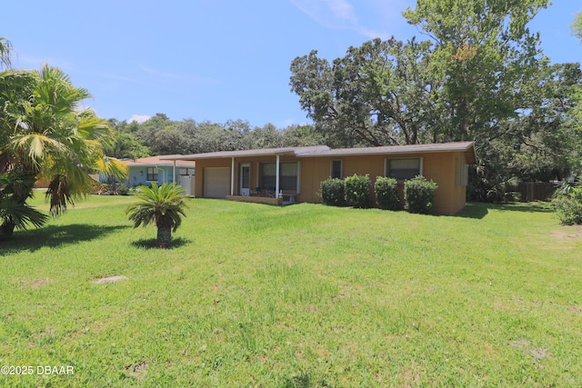 17 Putnam Ave, Ormond Beach, FL 32174 - rear view of property with an attached garage and a yard