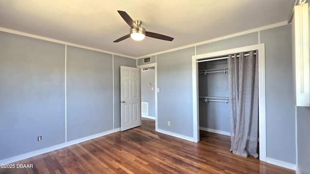 unfurnished bedroom with visible vents, baseboards, ornamental molding, wood finished floors, and a ceiling fan