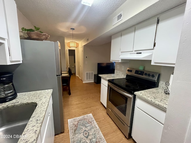 kitchen featuring white cabinetry, hanging light fixtures, stainless steel appliances, a textured ceiling, and light wood-type flooring