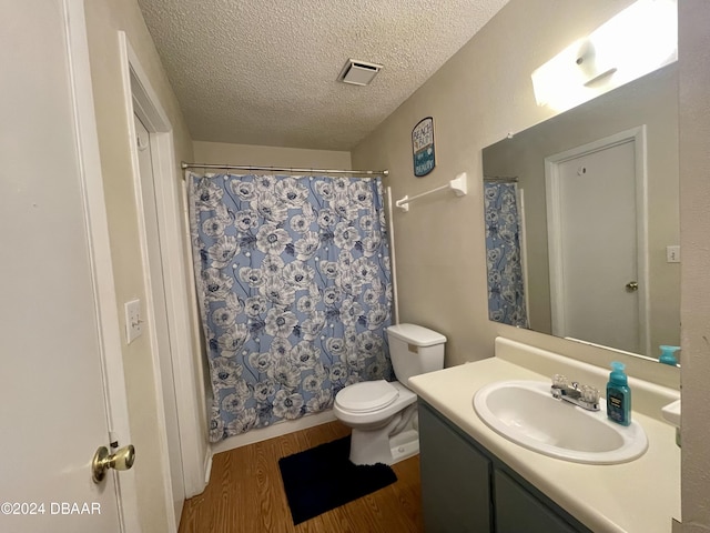 bathroom with a shower with shower curtain, vanity, a textured ceiling, wood-type flooring, and toilet